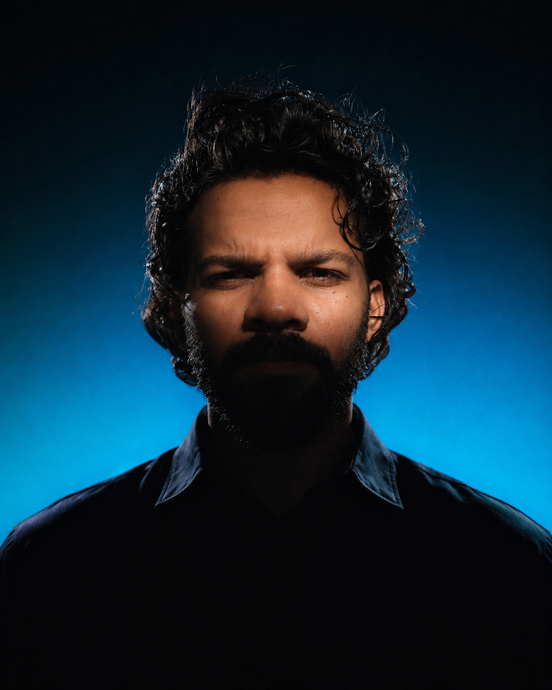 Portrait of Azil Zaneen against a blue backdrop